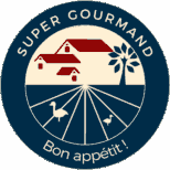 Super Gourmand logo with a circular design. At the top, the text 'RELAIS GOURMET' is arched over a navy blue background. Below, a stylized illustration of a red farmhouse with a white tree stands at the center of a field divided into radial sections, representing a landscape. At the bottom of the circle, it reads 'MAISON GASTRONOMIQUE AU PAYS BASQUE', indicating a gastronomic house in the Basque Country. The logo's background is cream and navy blue, and there are images of two cream-colored ducks at the bottom, one on each side, completing the design.